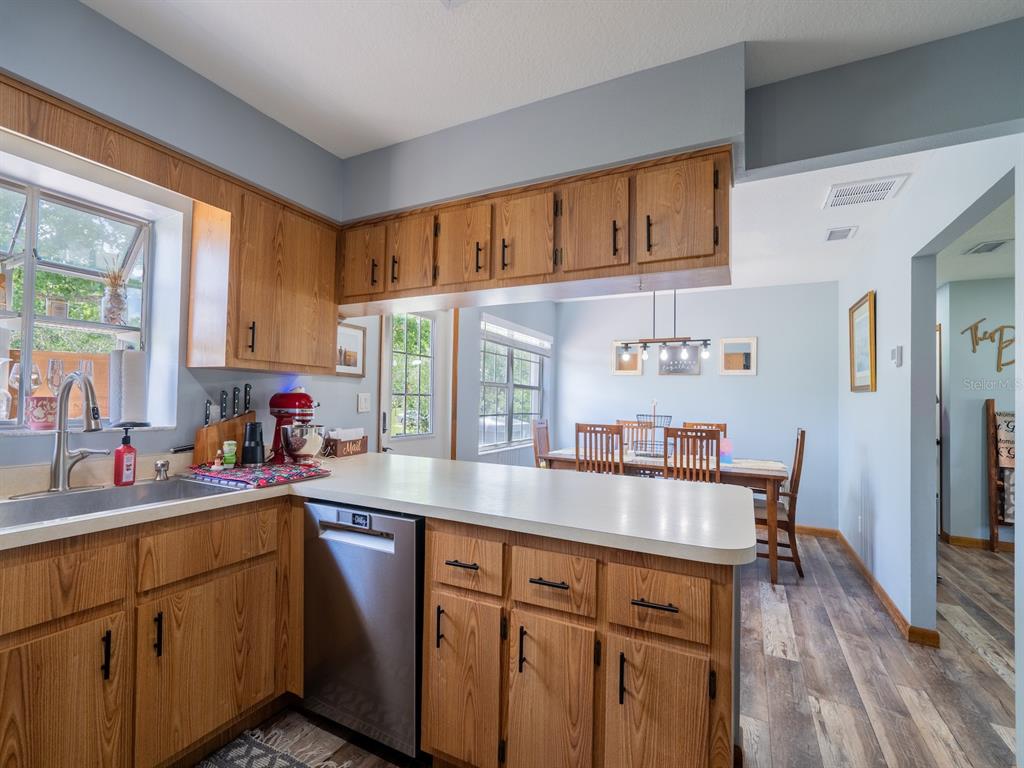 4381 Northeast 105th Place Anthony, FL 32617 - Photo 15 of 49 a kitchen with granite countertop a sink cabinets stainless steel appliances and a window