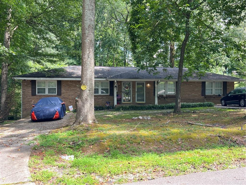 a view of a house with backyard and a tree