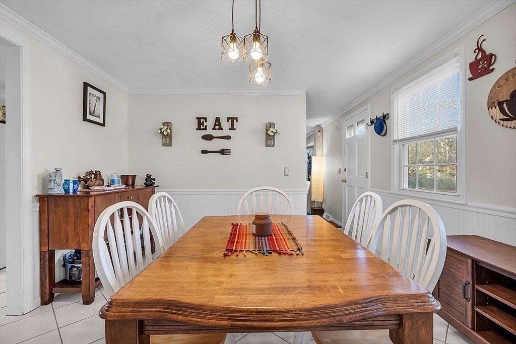 24 Edward Road Townsend, MA 01469 - Photo 22 of 38 a dining room with wooden floor a chandelier a wooden table and chairs