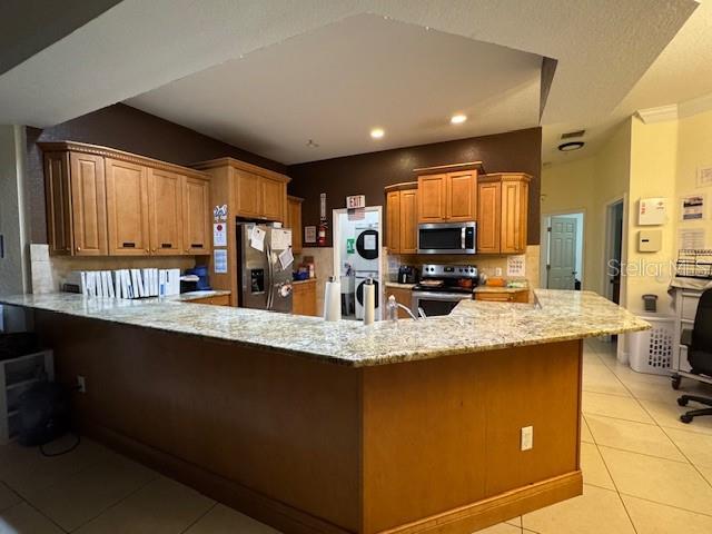 12140 Murray Avenue Largo, FL 33778 - Photo 2 of 23 a kitchen with stainless steel appliances granite countertop a sink a stove and a refrigerator