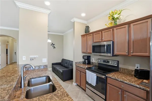 a kitchen with stainless steel appliances granite countertop a sink dishwasher stove and microwave with wooden floor