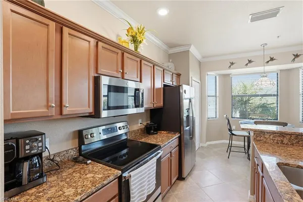 a kitchen with stainless steel appliances granite countertop a stove refrigerator sink and cabinets