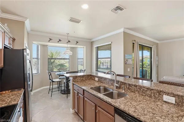a kitchen with granite countertop a sink and a refrigerator