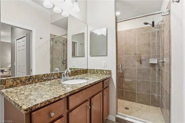 a bathroom with a granite countertop sink a shower and a mirror