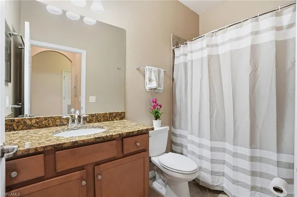 a bathroom with a granite countertop sink and a mirror