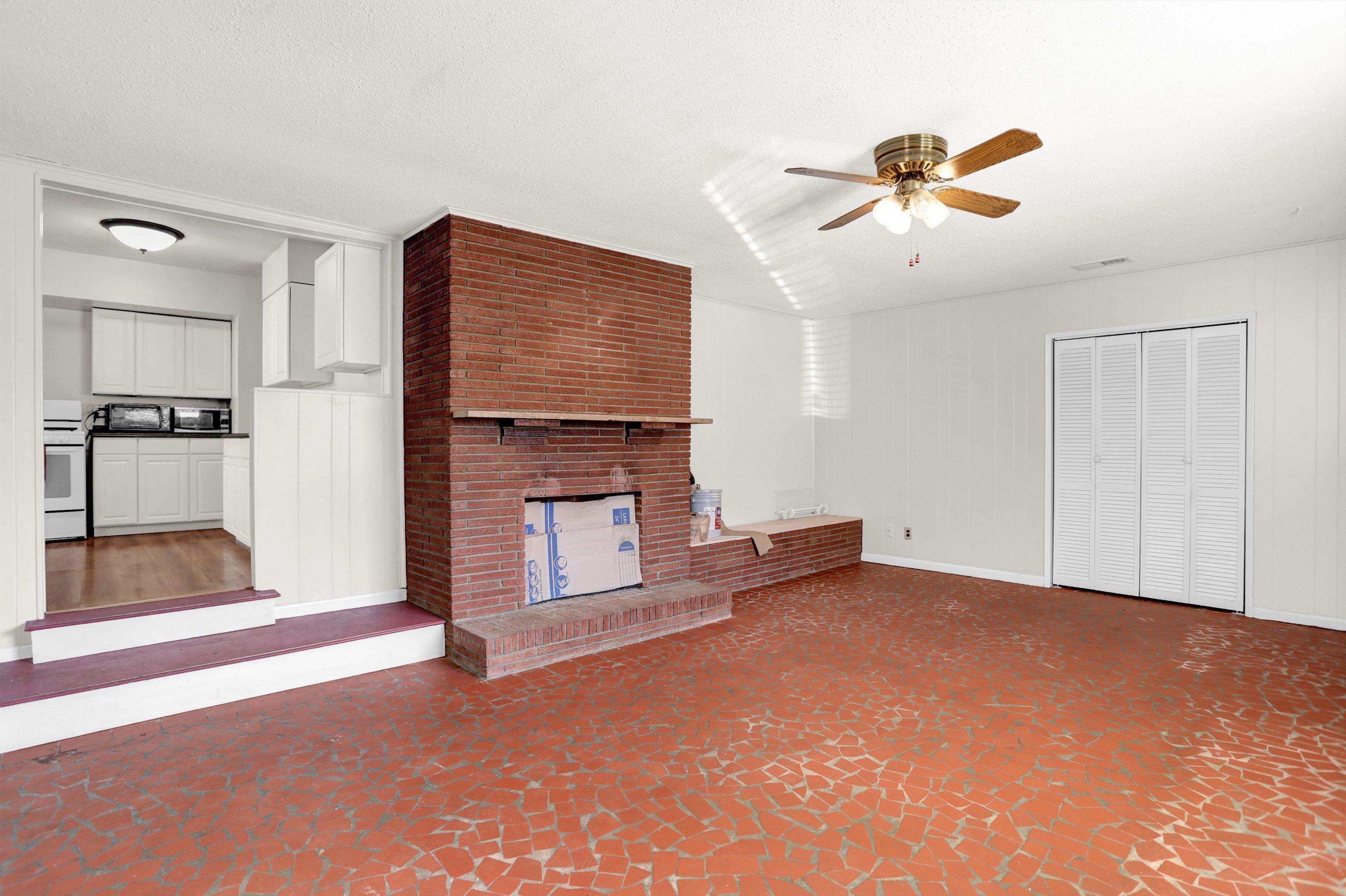 4931 Owen Road Memphis, TN 38122 - Photo 16 of 24 Unfurnished living room featuring visible vents, a ceiling fan, a brick fireplace, a textured ceiling, and baseboards