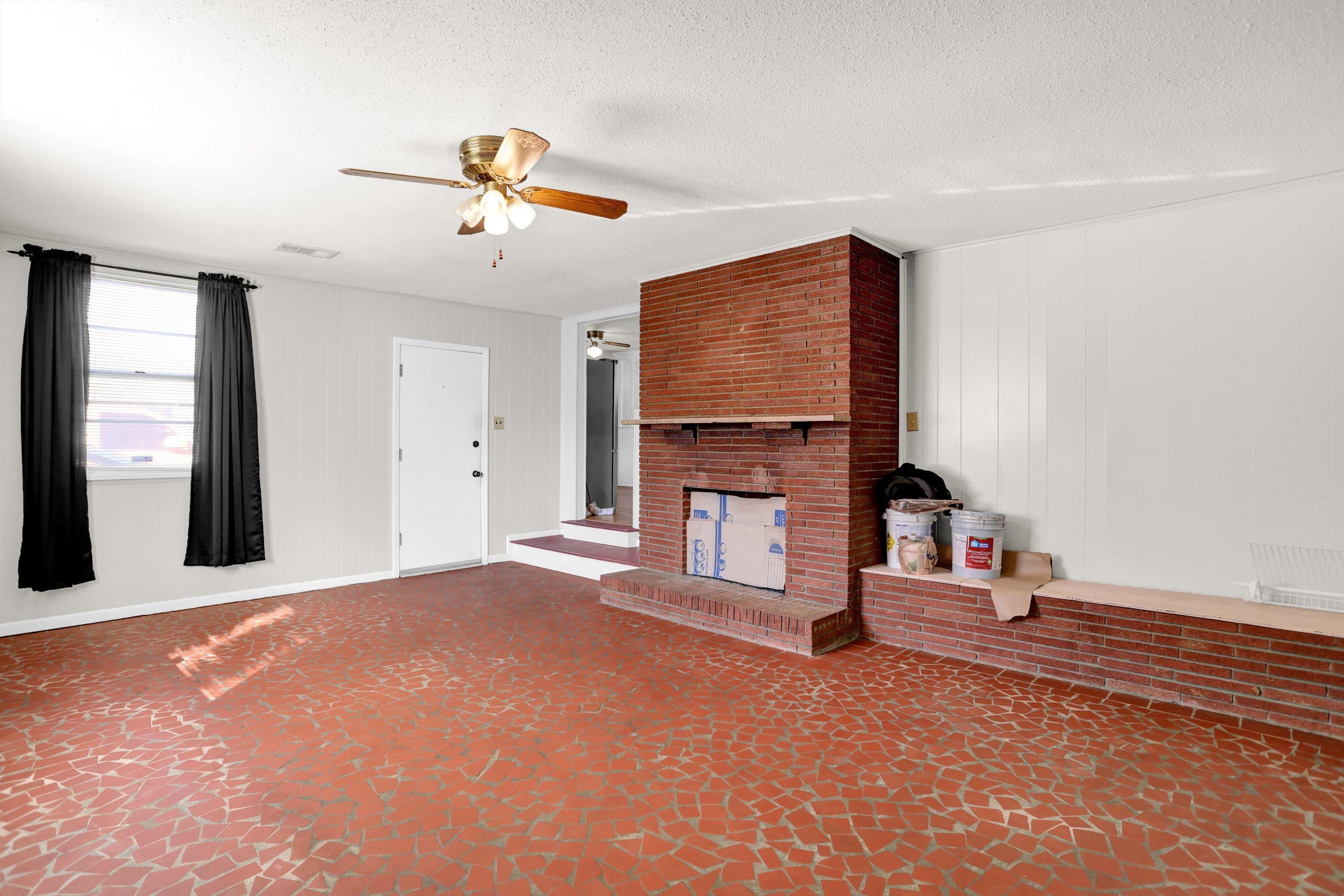 4931 Owen Road Memphis, TN 38122 - Photo 17 of 24 Unfurnished living room with a brick fireplace, ceiling fan, visible vents, and a textured ceiling