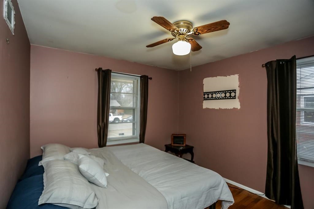4931 Owen Road Memphis, TN 38122 - Photo 23 of 24 Bedroom with a ceiling fan, multiple windows, visible vents, and dark wood-type flooring