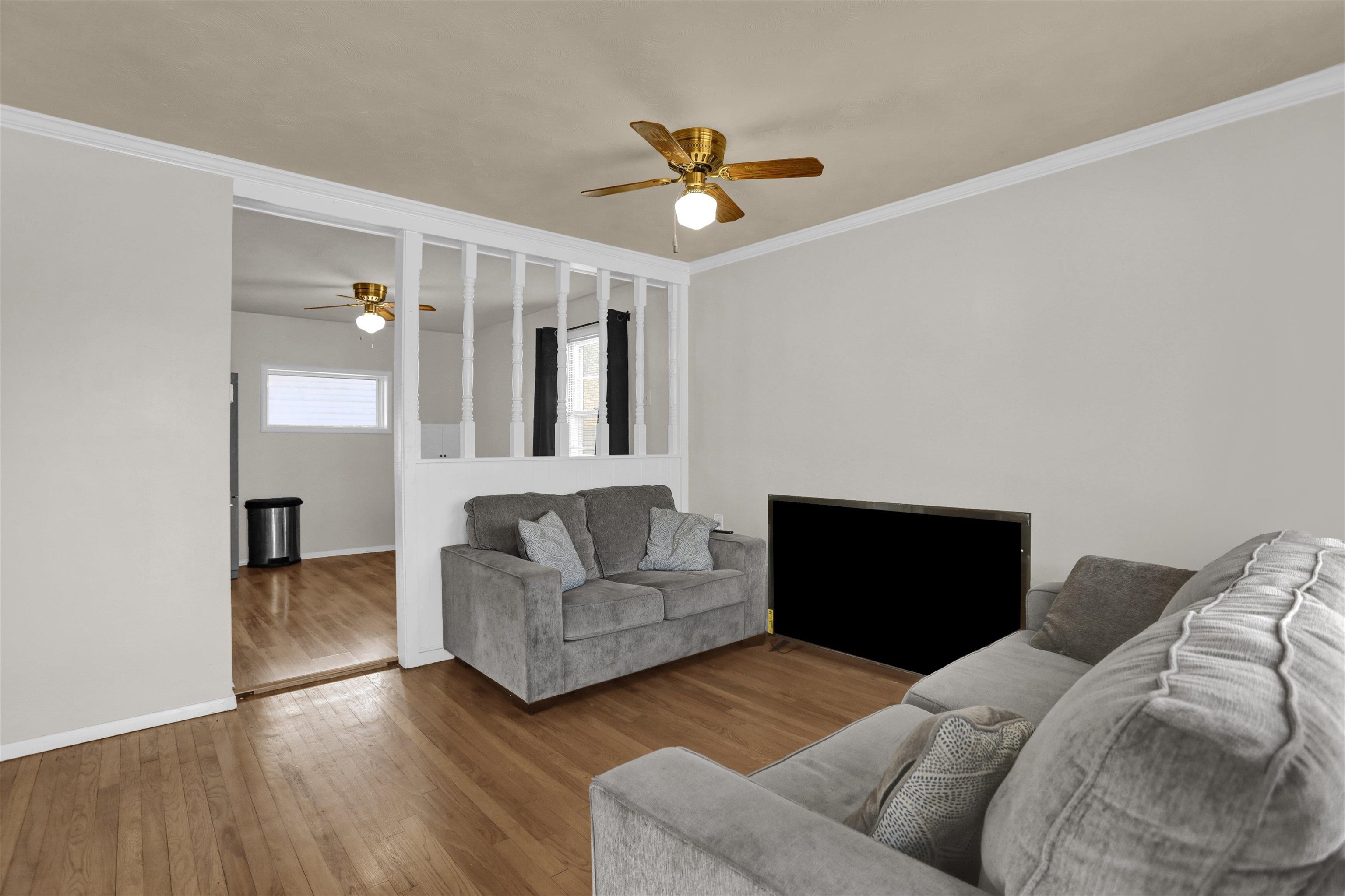 4931 Owen Road Memphis, TN 38122 - Photo 4 of 24 Living area featuring a ceiling fan, wood-type flooring, baseboards, and crown molding