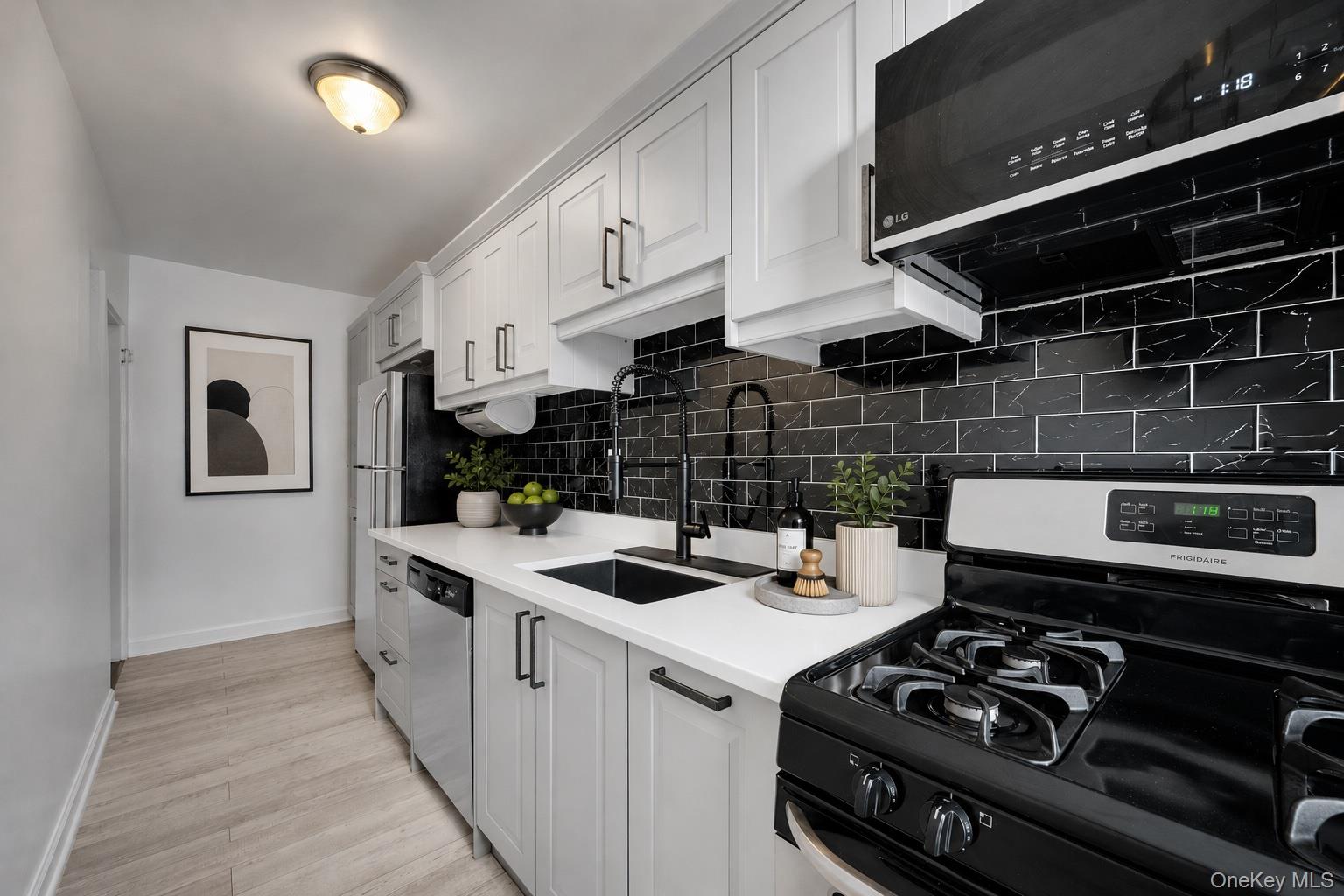 765 Bronx River Road, Unit 4A Bronxville, NY 10708 - Photo 5 of 15 A crisp white, black and gray palette brings a modern edge to this stylish kitchen.
