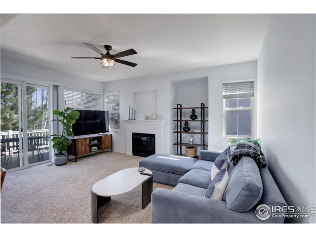 a living room with furniture a flat screen tv and a large window