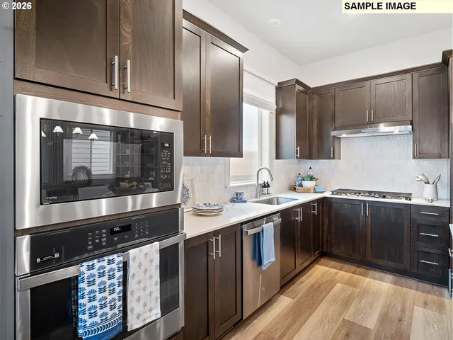 a kitchen with stainless steel appliances a sink stove and cabinets