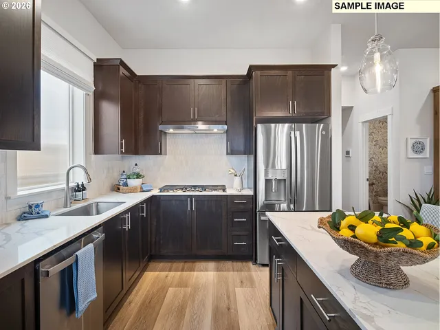 a kitchen with stainless steel appliances granite countertop a sink stove and refrigerator