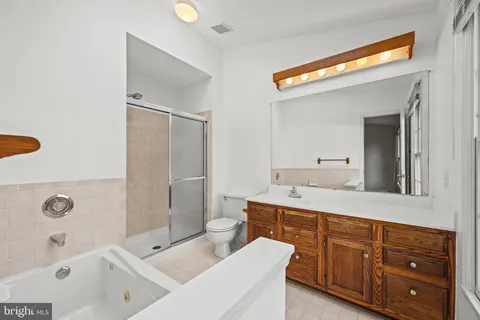a bathroom with a tub a sink and mirror