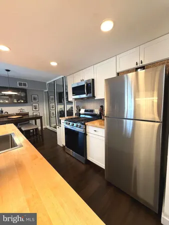 a kitchen with stainless steel appliances granite countertop a refrigerator a stove a sink and a microwave