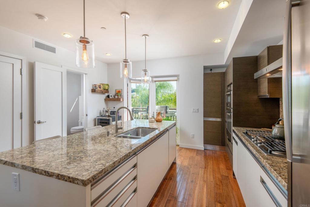90 North Coast Highway 101, Unit 310 Encinitas, CA 92024 - Photo 5 of 24 a kitchen with stainless steel appliances granite countertop a sink a stove and a refrigerator