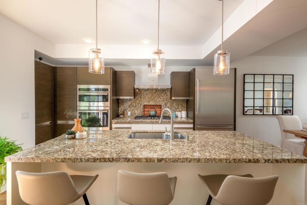 90 North Coast Highway 101, Unit 310 Encinitas, CA 92024 - Photo 6 of 24 a kitchen with granite countertop a sink and a refrigerator