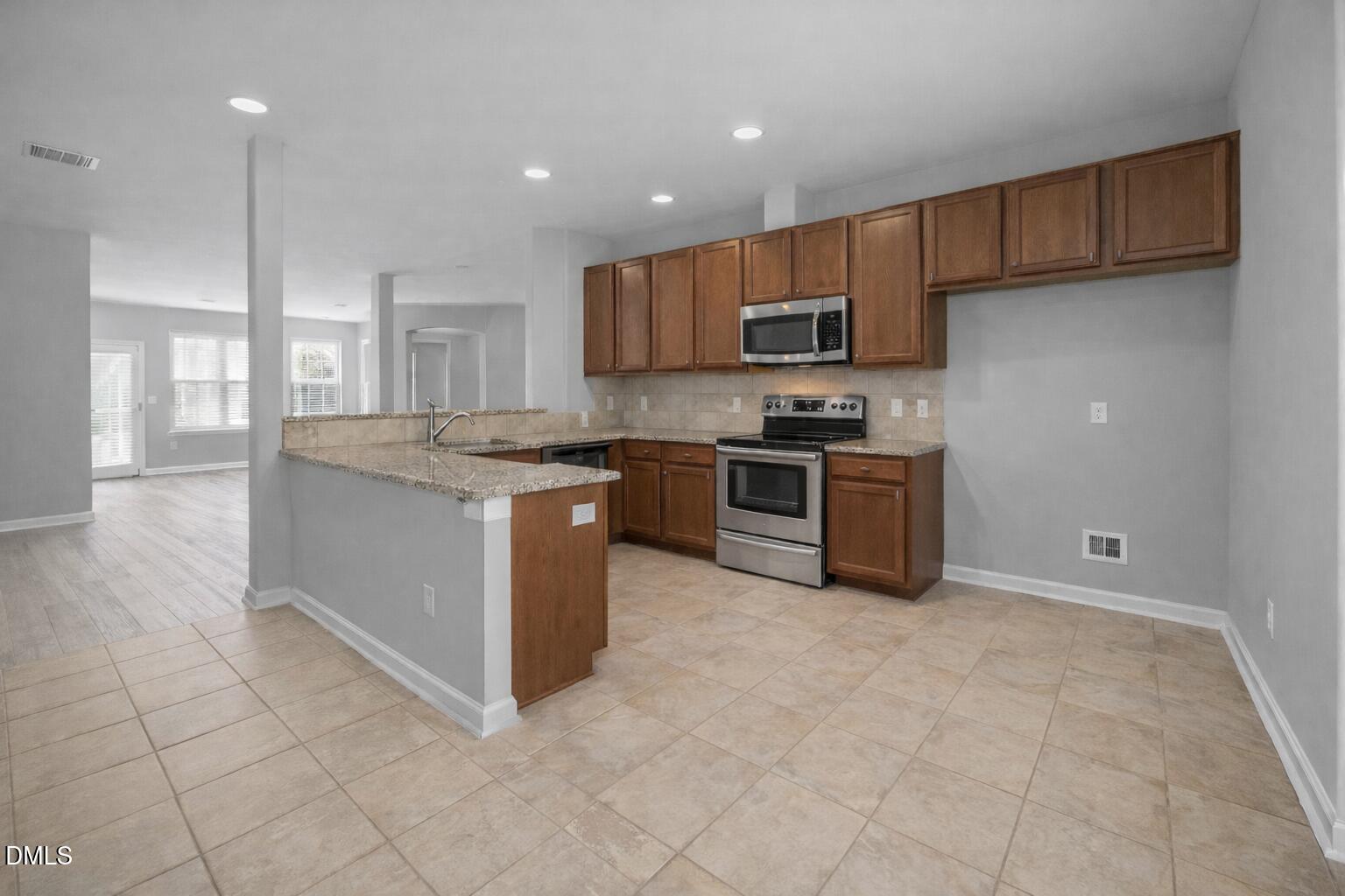 6626 Clarksburg Place Raleigh, NC 27616 - Photo 10 of 25 a kitchen with stainless steel appliances granite countertop a stove top oven a sink a counter top space and cabinets