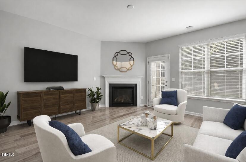 6626 Clarksburg Place Raleigh, NC 27616 - Photo 8 of 25 a living room with furniture a fireplace and a flat screen tv