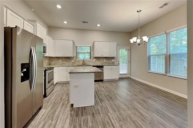 a kitchen with stainless steel appliances a refrigerator sink and cabinets