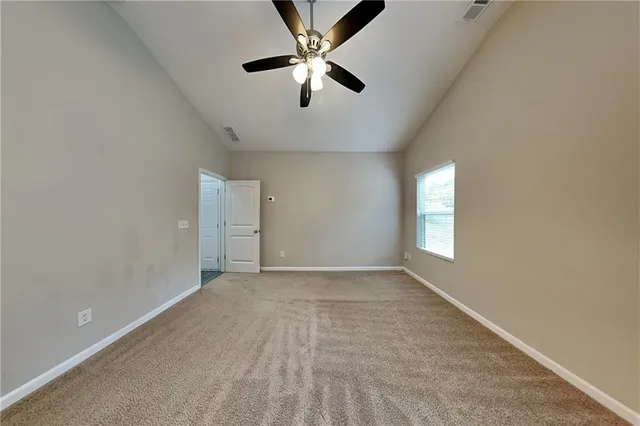 an empty room with window and ceiling fan