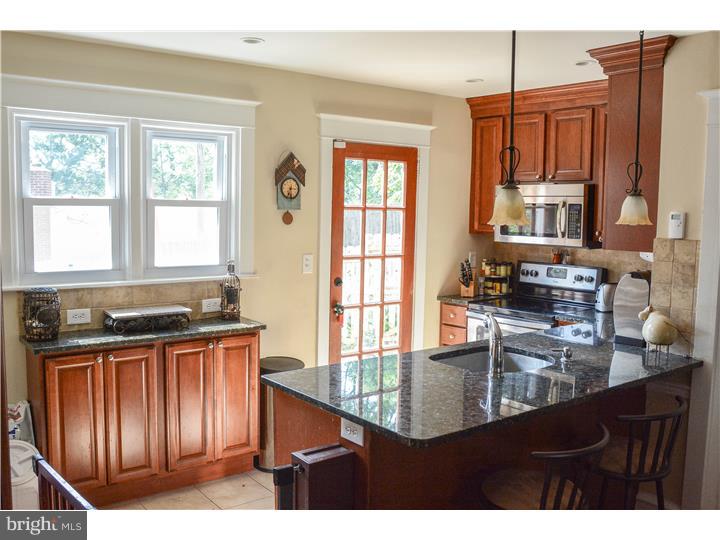 29 West Ridge Road Media, PA 19063 - Photo 8 of 12 a kitchen with wooden cabinets a sink a stove and a window