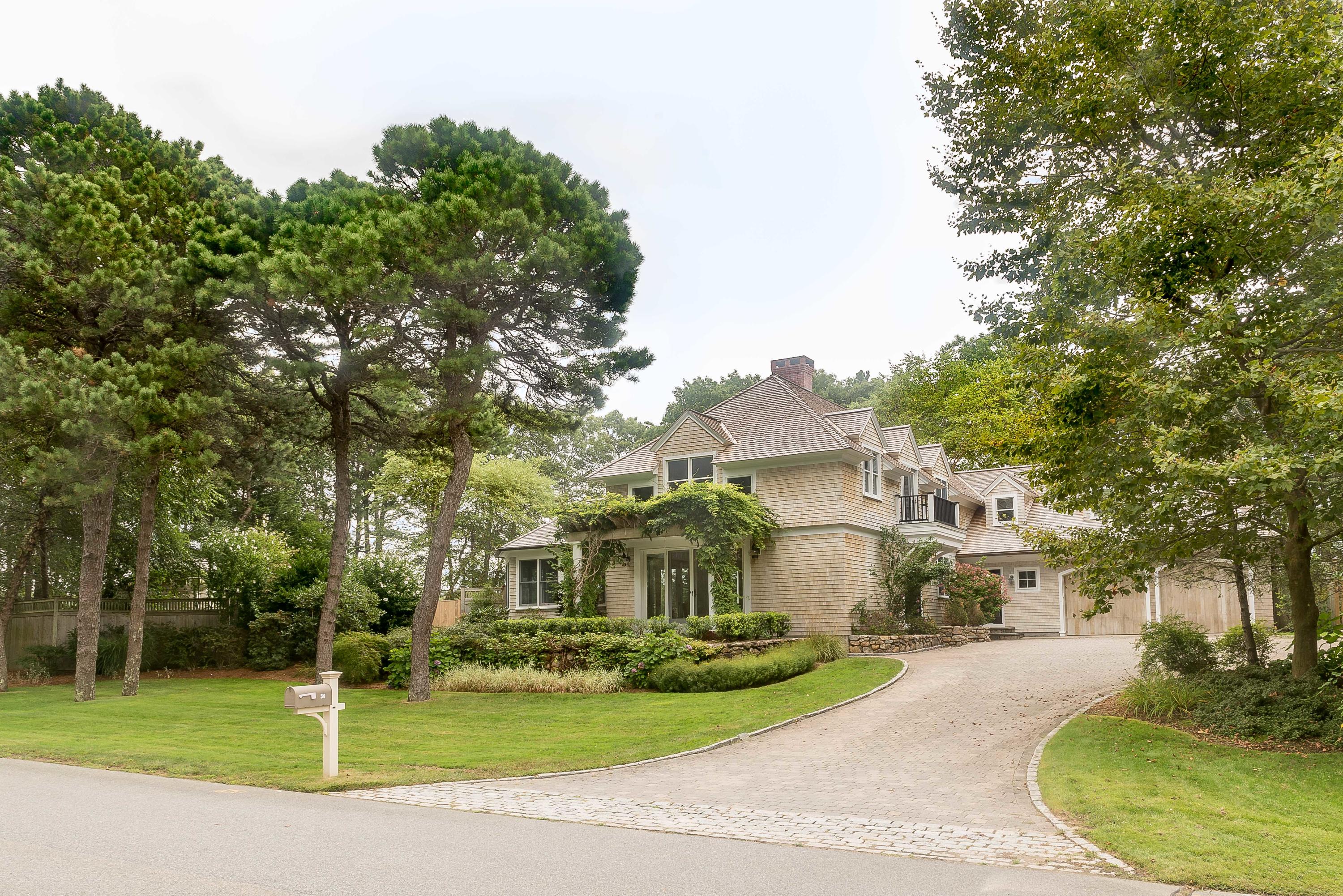 54 Gullane Road Mashpee, MA 02649 - Photo 3 of 25 a view of a white house next to a yard with big trees