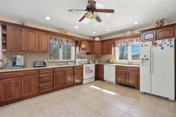a kitchen with stainless steel appliances granite countertop a refrigerator a sink dishwasher a stove with wooden cabinets and floor