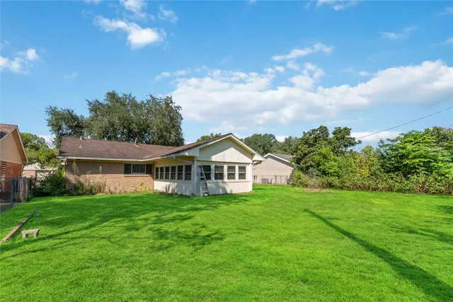 a view of a house with a big yard and large trees