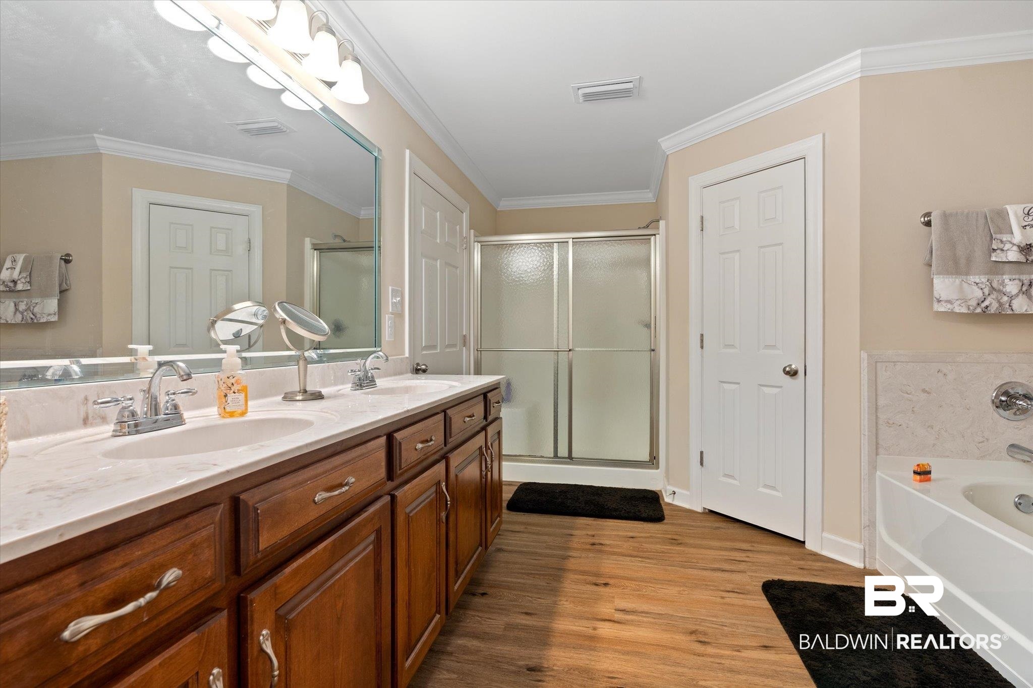 734 West Section Avenue Foley, AL 36535 - Photo 17 of 50 Bathroom featuring a shower stall, wood finished floors, a garden tub, and a sink