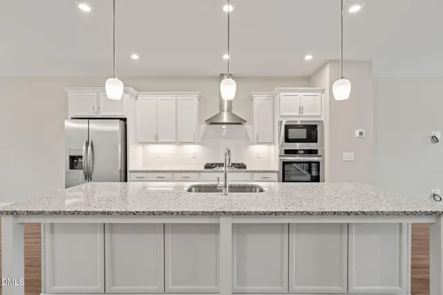 a kitchen with kitchen island granite countertop a sink a counter and chairs