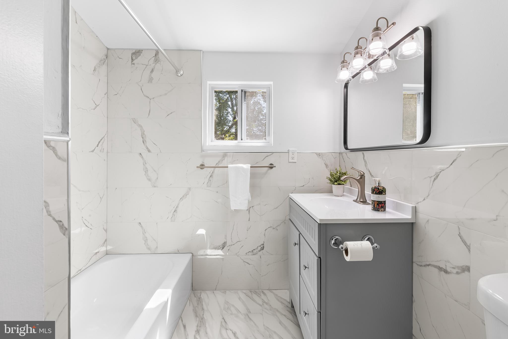 343 Sugartown Road, Unit B Wayne, PA 19087 - Photo 10 of 14 a bathroom with a sink a toilet and a mirror