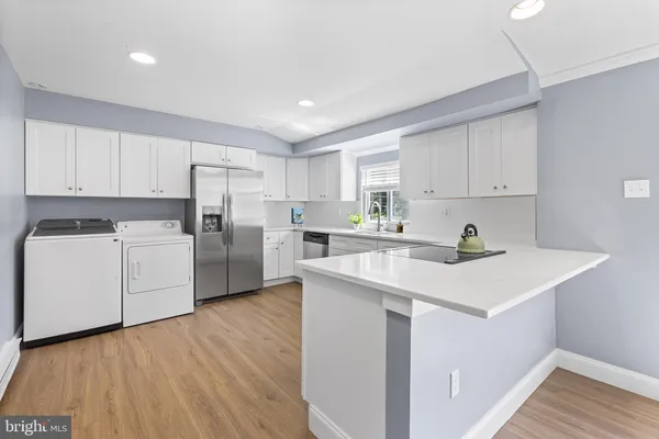 a view of a kitchen with wooden floor and electronic appliances