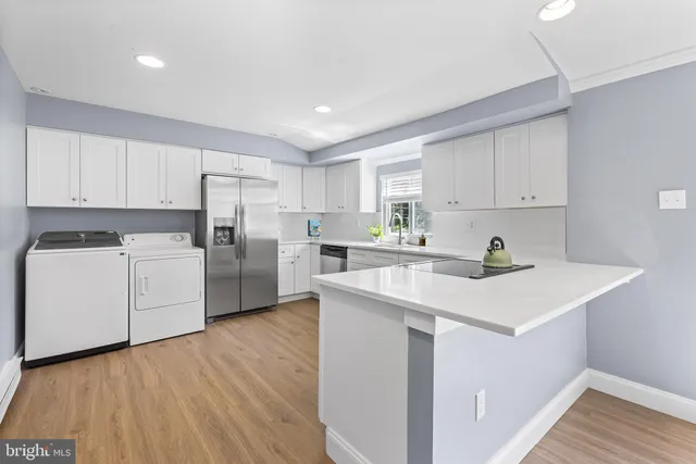 a view of a kitchen with wooden floor and electronic appliances