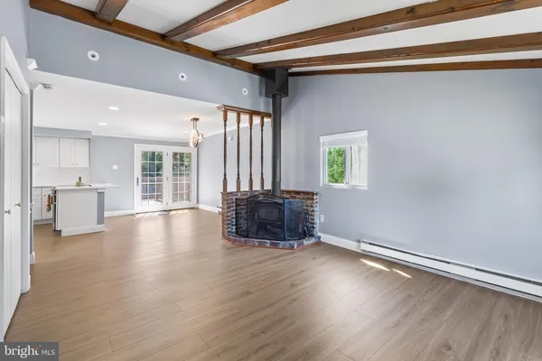 a kitchen with a stove and wooden floor