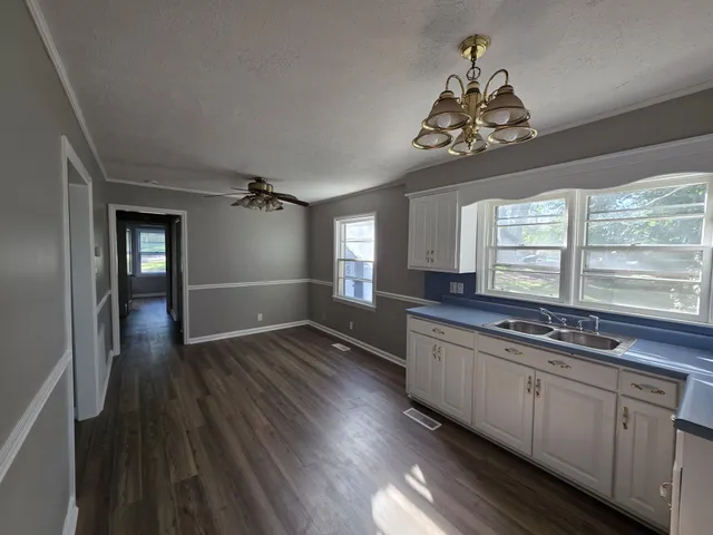 a kitchen with a sink and wooden floor
