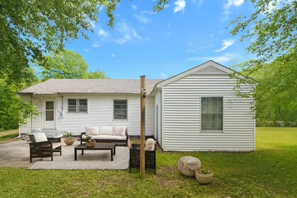 a view of a house with backyard and sitting area