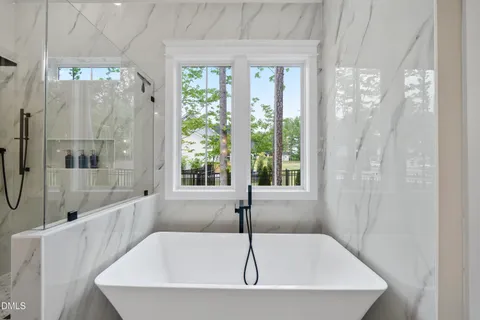 a bathroom with a granite countertop tub sink and mirror