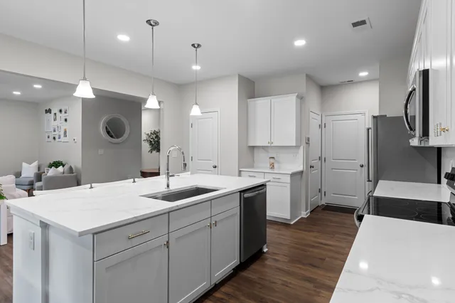 a kitchen with a sink a counter space appliances and cabinets