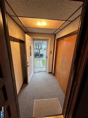 a view of hallway with window and wooden floor