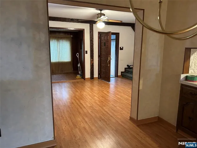 a view of a room with wooden floor and kitchen