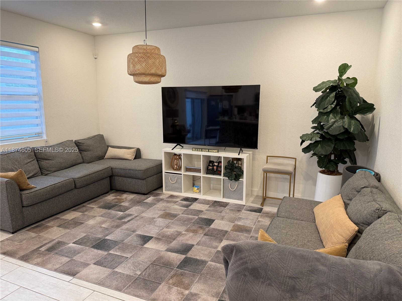 793 Southeast 19th Street Homestead, FL 33034 - Photo 6 of 13 a living room with furniture a flat screen tv and a chandelier