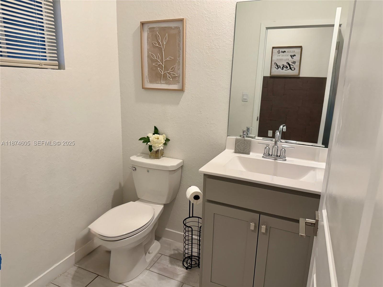 793 Southeast 19th Street Homestead, FL 33034 - Photo 9 of 13 a bathroom with a sink mirror and toilet