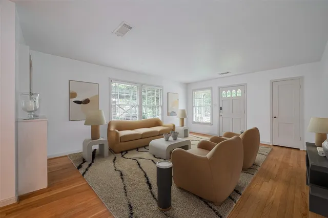 a living room with furniture wooden floor and a window