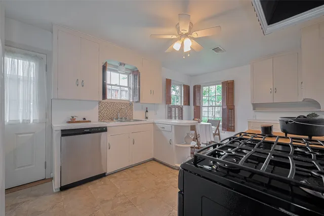 a kitchen with a stove and white cabinets