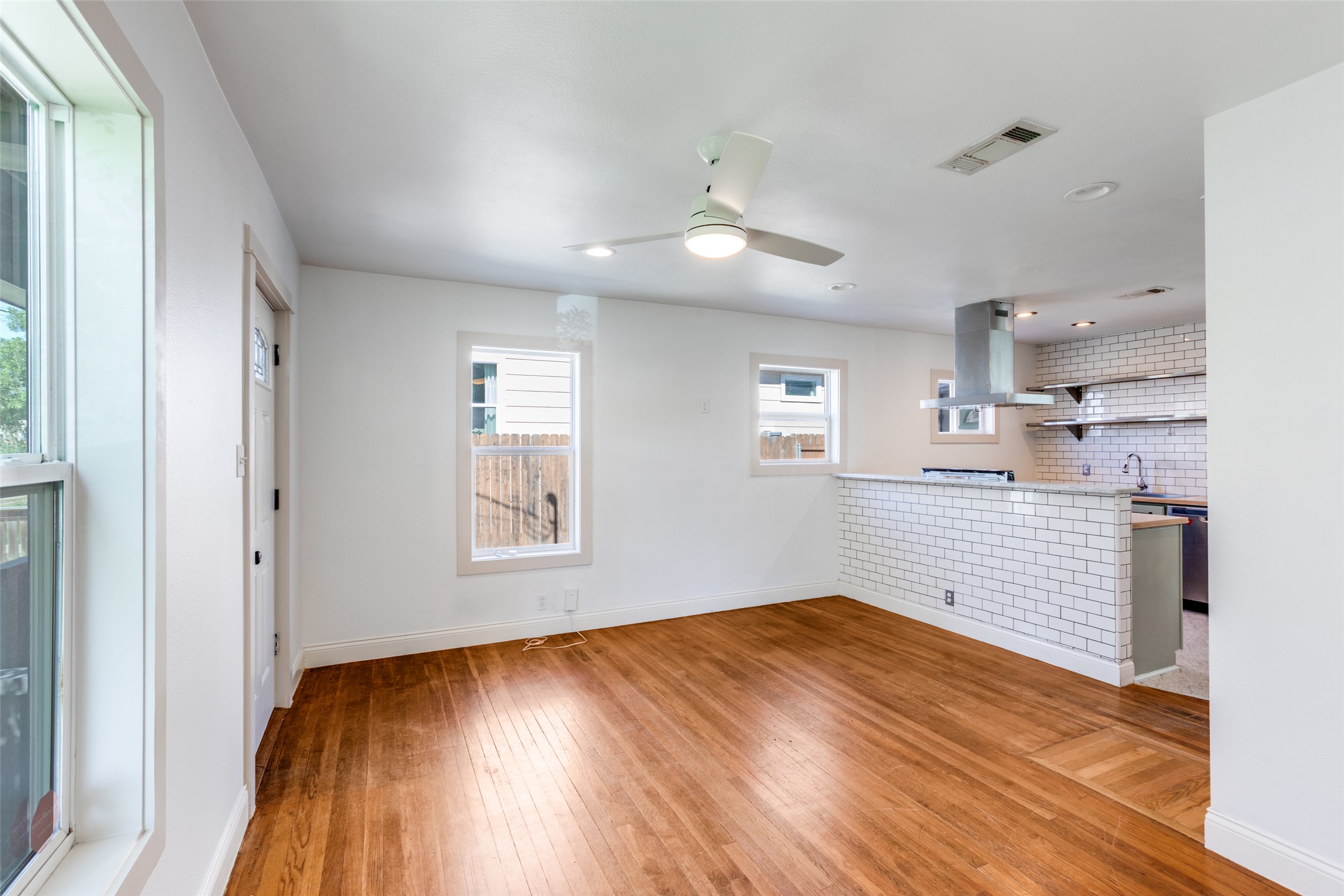 2012 Payne Avenue, Unit A Austin, TX 78757 - Photo 9 of 35 an empty room with wooden floor cabinet and windows