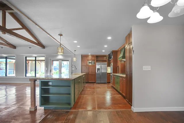 a kitchen with a refrigerator and wooden cabinets