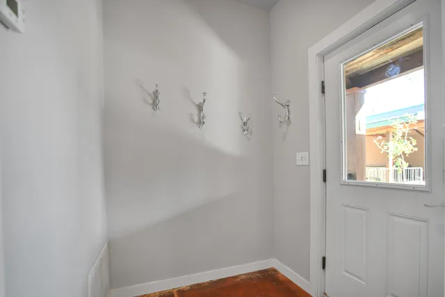 an empty room with windows and chandelier fan