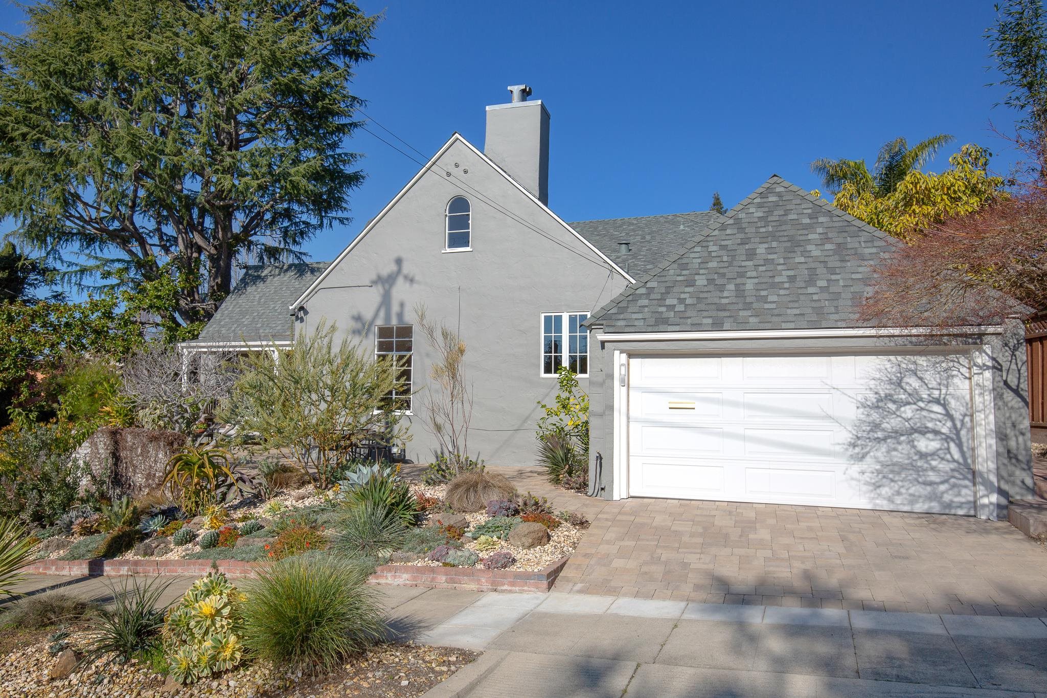 3570 Jordan Road Oakland, CA 94619 - Photo 54 of 60 View of home's exterior featuring a chimney, stucco siding, a shingled roof, decorative driveway, and a garage