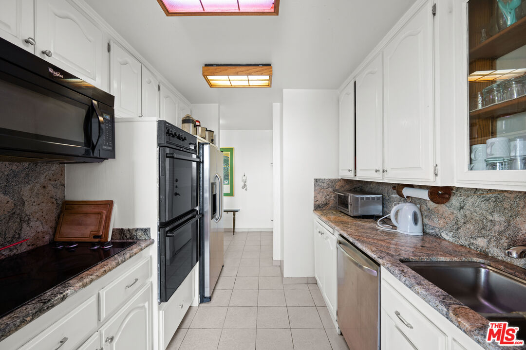 100 South Doheny Drive, Unit 512 Los Angeles, CA 90048 - Photo 16 of 37 a kitchen with stainless steel appliances granite countertop a sink stove and refrigerator